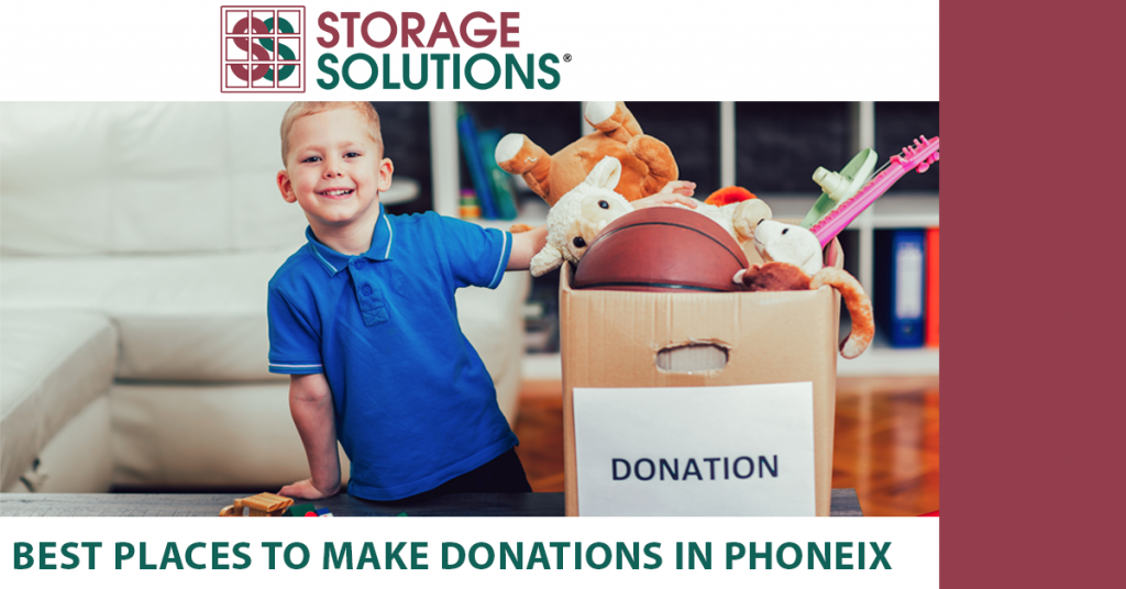 child next to box of toys and clothes for a donation center in phoenix